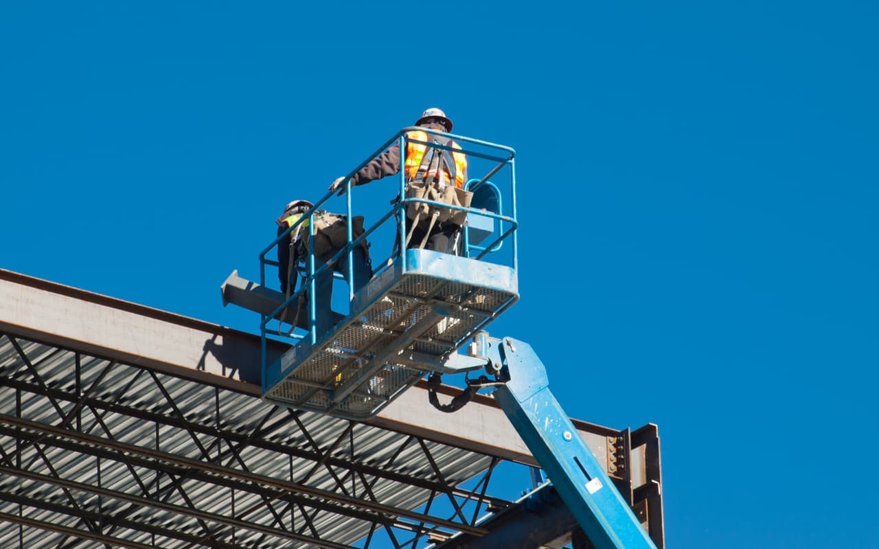 Hoogwerker bij de staalconstructie van een bedrijfspand in aanbouw